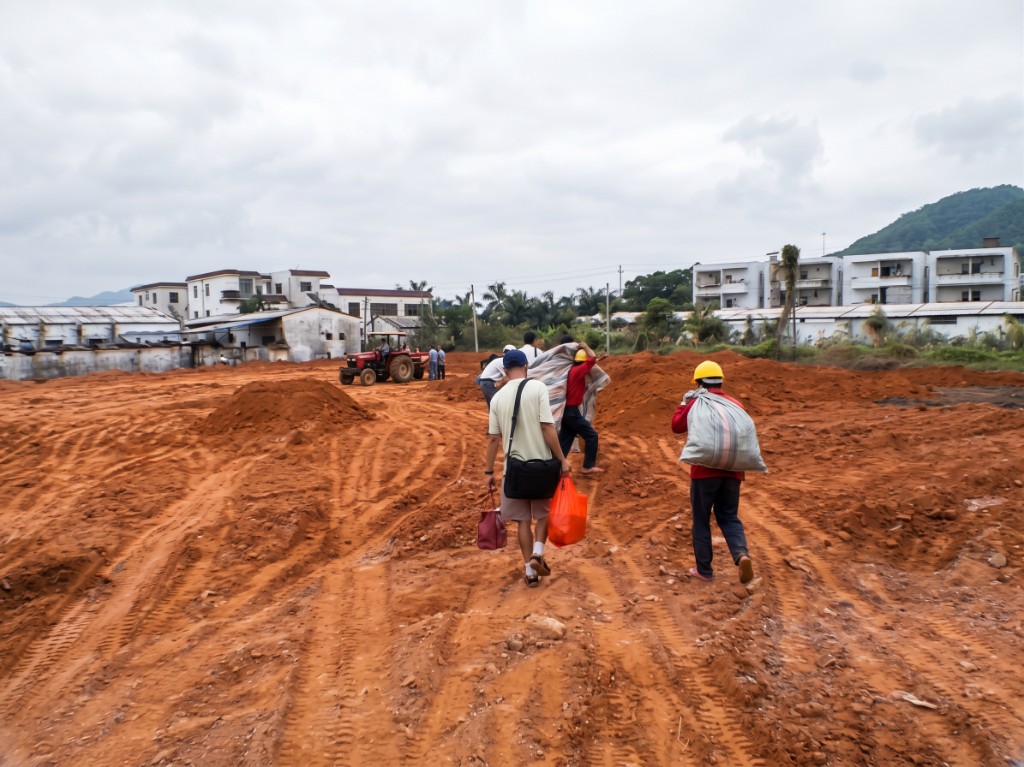 Clearing cultivated farmland — open earth before the factory rose.